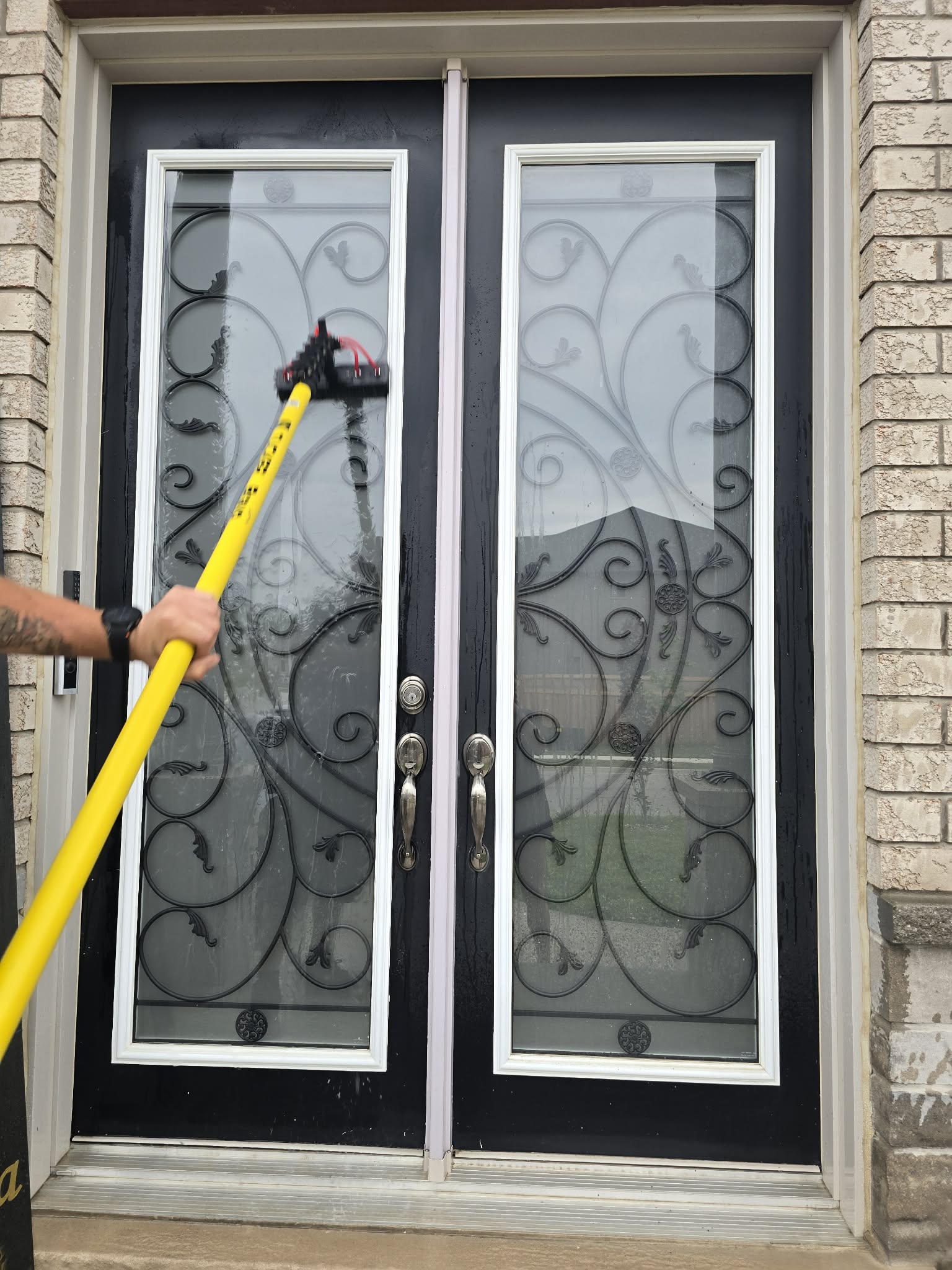 Worker pressure washing interlock paver patio, Niagara